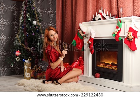 beautiful woman near the fireplace in winter house. celebrating christmas, studio