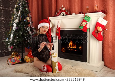 beautiful woman near the fireplace in winter house. selebrating christmas, studio