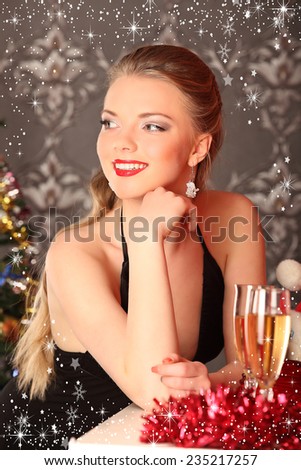 Woman celebrating christmas, smiling woman in evening dress with glass of sparkling champagne, studio