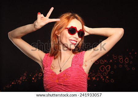 Girl with heart-shaped glasses and closed eyes smiling, studio