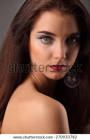 Beautiful girl with creative colorful makeup on a dark background studio