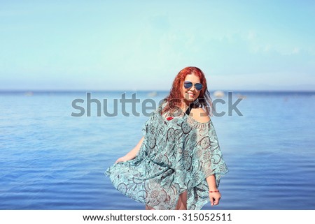 Image of red-haired plus size woman resting on coast