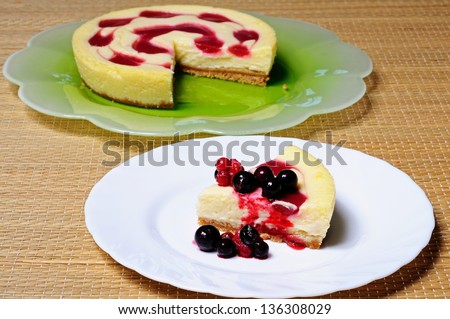 Cheesecake topped with raspberry syrup and fresh red berries.