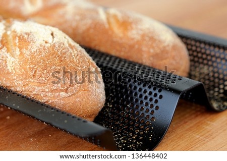 Freshly baked French baguettes in a baguette tray.