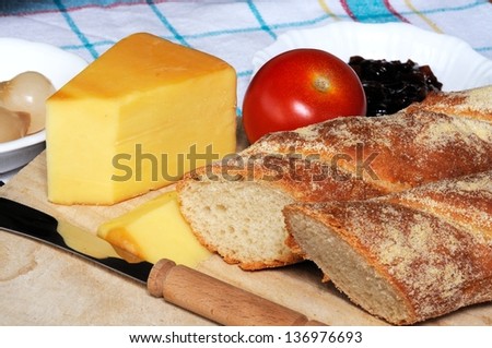 Ploughmans lunch comprising of white bread, cheddar cheese and pickle on a wooden chopping board, England, UK, Western Europe.