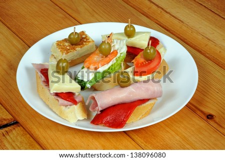 Spanish tapas, Prawn with cream cheese, Tortilla, Brie with red pepper, cheese and tomato, ham rolled with cream cheese, ham, red pepper and cheese, topped with a green olive on crusty bread.