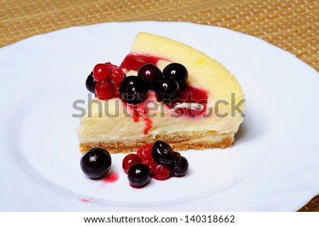 Cheesecake topped with raspberry syrup and fresh red berries.