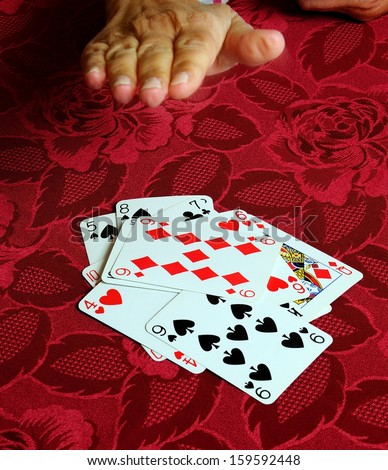 Hand coming down on card game of snap.