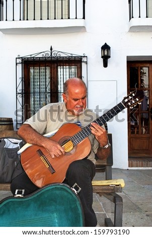 FRIGILIANA, SPAIN - OCTOBER 6, 2009 - Guitarist busking in the town Square, Frigiliana, Spain, Circa October 6, 2009.