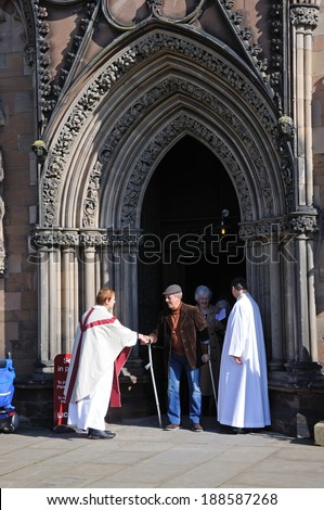 LICHFIELD, ENGLAND - MARCH 9, 2014 - Clergyman greeting members of the congregation outside the Cathedral West Front door, Lichfield, Staffordshire, England, UK, Western Europe, March 9, 2014.