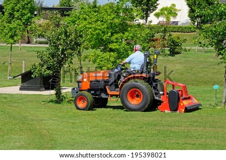 ALREWAS, UK - MAY 21, 2014 - Gardener on a ride on mower mowing the lawns at the National Memorial Arboretum, Alrewas, Staffordshire, England, UK, Western Europe, May 21, 2014.