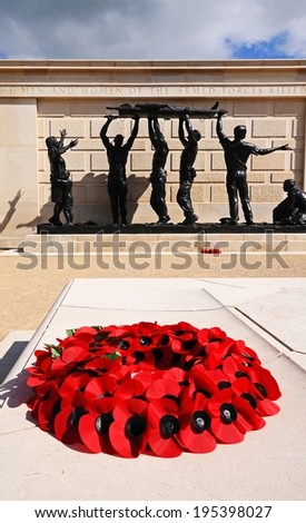 ALREWAS, UK - MAY 21, 2014 - Poppy wreath inside the inner circle of the Armed Forces Memorial with statue to the rear, National Memorial Arboretum, Alrewas, Staffordshire, UK, Europe, May 21, 2014.