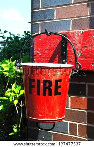 Red Victorian fire bucket on the railway platform, Brownhills West Railway Station, Staffordshire, England, UK, Western Europe.