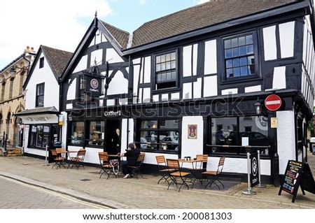 LEOMINSTER, UNITED KINGDOM - JUNE 5, 2014 - Couple sitting at a table outside a coffee shop in Corn Square, Leominster, Herefordshire, England, UK, Western Europe, June 5, 2014.