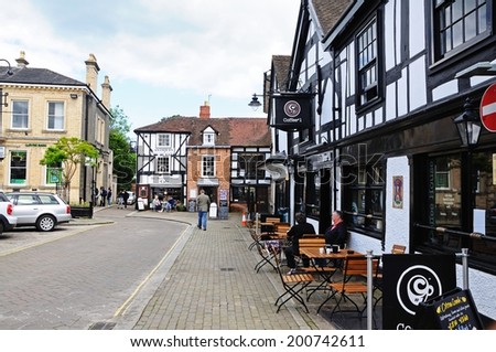 LEOMINSTER, UK - JUNE 5, 2014 - Couple sitting at a table outside a coffee shop in Corn Square with The Merchants House cafe to the rear, Leominster, Herefordshire, England, UK, June 5, 2014.