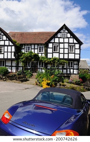 PEMBRIDGE, UK - JUNE 5, 2014 - View of the New Inn Public House Market Square with a blue Porsche Boxter in the foreground, Pembridge, Herefordshire, England, UK, June 5, 2014.