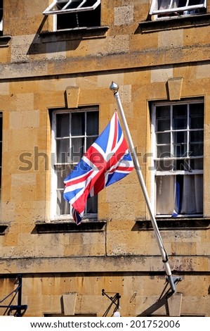 Union Jack flag on a flagpole attached to a Cotswold stone building along the High Street, Chipping Campden, The Cotswolds, Gloucestershire, England, UK, Western Europe.