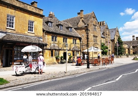 BROADWAY, UK - JUNE 12, 2014 - Ice Cream seller and pavement cafe along High Street with the Lygon Arms Hotel to the rear, Broadway, Cotswolds, Worcestershire, England, UK, Europe, June 12, 2014.
