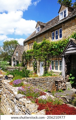 LOWER SLAUGHTER, UK - JUNE 12, 2014 - Pretty stone cottages in the centre of the village, Lower Slaughter, Cotswolds, Gloucestershire, England, UK, Western Europe, June 12, 2014.