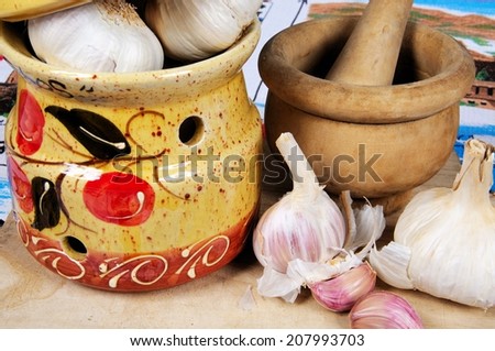 Ceramic garlic pot, garlic bulbs and pestle and mortar on a wooden chopping board, Calypso, Costa del Sol, Malaga Province, Andalusia, Spain, Western Europe.