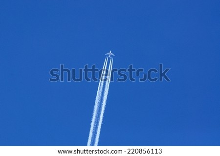 MANCHESTER, UNITED KINGDOM - JULY 22, 2014 - Emirates Airbus A380 with contrails against a blue sky, July 22, 2014.