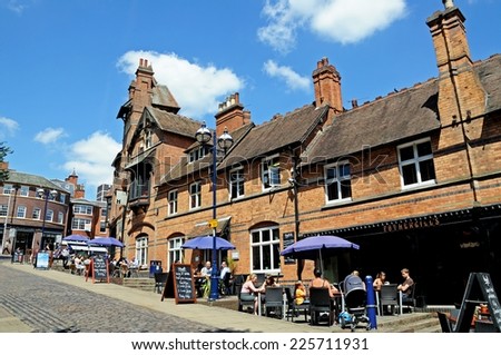NOTTINGHAM, UNITED KINGDOM - JULY 17, 2014 - People relaxing at tables outside Fothergills pub opposite the castle entrance, Castle Road, Nottingham, Nottinghamshire, England, UK, July 17, 2014.