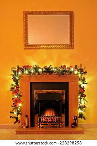 Coal effect fire with wooden surround and Christmas garland, Spain, Western Europe.