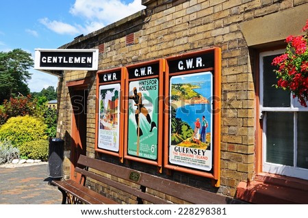 ARLEY, UK - JULY 10, 2014 - Old advertisement posters on the railway station wall with the Gentlemens toilets at the end, Severn Valley Railway, Arley, Worcestershire, England, UK, July 10, 2014.