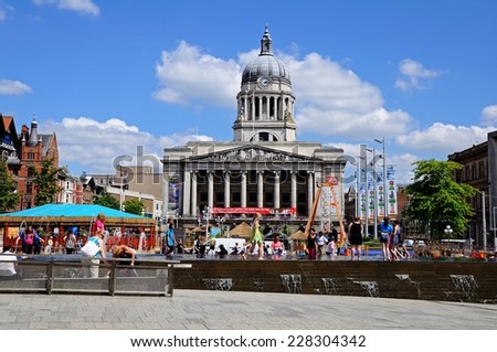 NOTTINGHAM, UK - JULY 17, 2014 - Council House also known as the city hall in the Old Market Square people paddling in a fountain in the foreground, Nottingham, England, UK, July 17, 2014.