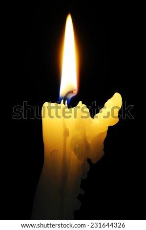 White candle with wax running down side of candle against a black background.