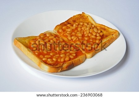 Two rounds of baked beans on toast on a white plate.