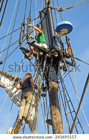 GLOUCESTER, UK - SEPTEMBER 8, 2014 - Two men attending to the rigging on the tall ship moored at Gloucester Docks, Gloucester, Gloucestershire, England, UK, Western Europe, September 8, 2014.