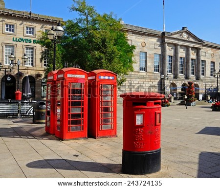 STAFFORD, UK - SEPTEMBER 11, 2014 - Red post box and telephone boxes with the Shire Hall Gallery to the rear in Market Square, Stafford, Staffordshire, England, UK, Western Europe, September 11, 2014.