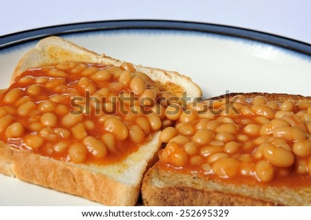 Two rounds of baked beans on toast, one on white bread and one on wholemeal.