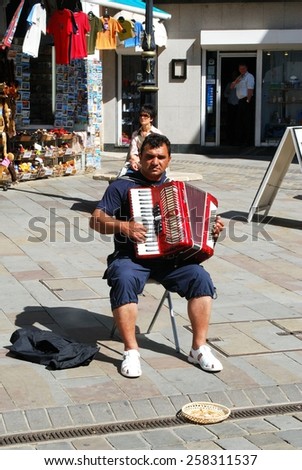 GIBRALTAR, UK - APRIL 20 2009 - Piano accordionist playing for money in Main Street, Gibraltar, United Kingdom, Western Europe, April 20, 2009.