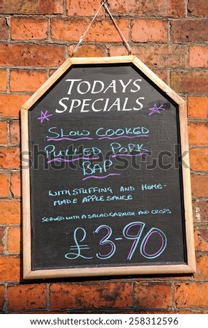 Todays Special chalkboard against a brick wall advertising Pulled Pork Bap