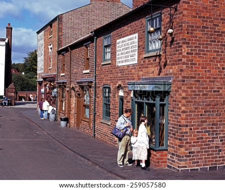 DUDLEY, UK - SEPTEMBER 23, 1997 - People looking at Victorian shops along the main village shopping street at the Black Country Living Museum, Dudley, West Midlands, England, UK, September 23, 1997.