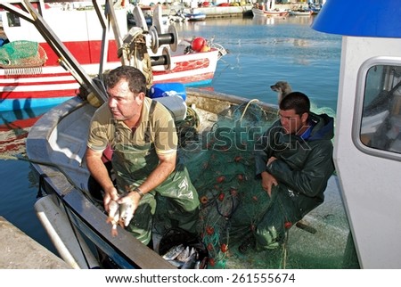 PUERTO DE LA ATUNARA, SPAIN - JULY 7, 2009 - Fishermen sorting fish on a fishing boat in the port, Puerto de la Atunara, Costa del Sol, Cadiz Province, Andalusia, Spain, Western Europe, July 7, 2009.