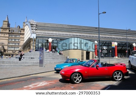 LIVERPOOL, UNITED KINGDOM - JUNE 11, 2015 - View of Lime Street Railway Station with two soft top Mazda sports care in the foreground, Liverpool, Merseyside, England, UK, Western Europe.