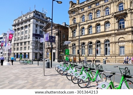 LIVERPOOL, UNITED KINGDOM - JUNE 11, 2015 - Tourist sights signpost in Derby Square on the Corner of James Street with City hire bikes in the foreground, Liverpool, England, UK, June 11, 2015.