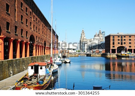LIVERPOOL, UNITED KINGDOM - JUNE 11, 2015 - Yachts moored in Albert Dock with the Three Graces to the rear, Liverpool, Merseyside, England, UK, Western Europe, June 11, 2015.
