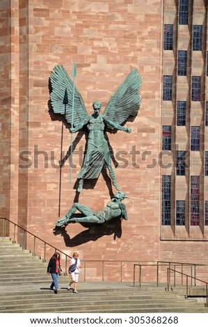 COVENTRY, UNITED KINGDOM - JUNE 4, 2015 - Statue of St Michael holding a spear over the devil (Michael and the Devil) on the wall of the new Cathedral, Coventry, England, UK, June 4, 2015.