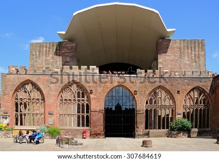 COVENTRY, UK- JUNE 4, 2015 - Tourists sitting on a bench inside the old Cathedral ruin with the entrance to the new Cathedral to the rear, Coventry, West Midlands, England, UK, June 4, 2015