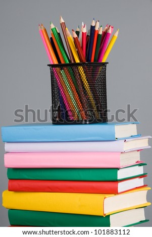 Colored pencils and a stack of books on the table