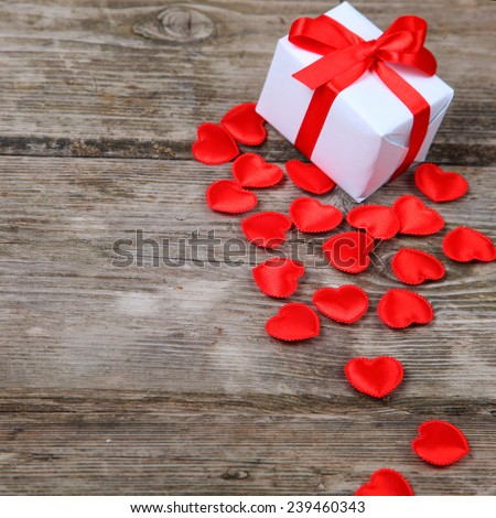 Holidays gift and red hearts on wooden background. Valentines day background.