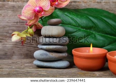 Aromatherapy spa set. Zen stones, candles and orchid on wooden background