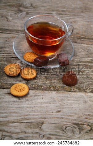 Cup of tea and chocolates on the wooden table