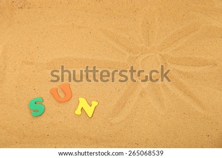 Drawn sun on the sand and the word \