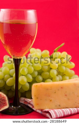 wine, cheese and fruits on a red background