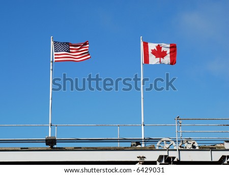 Flags flying at a US and Canadian border